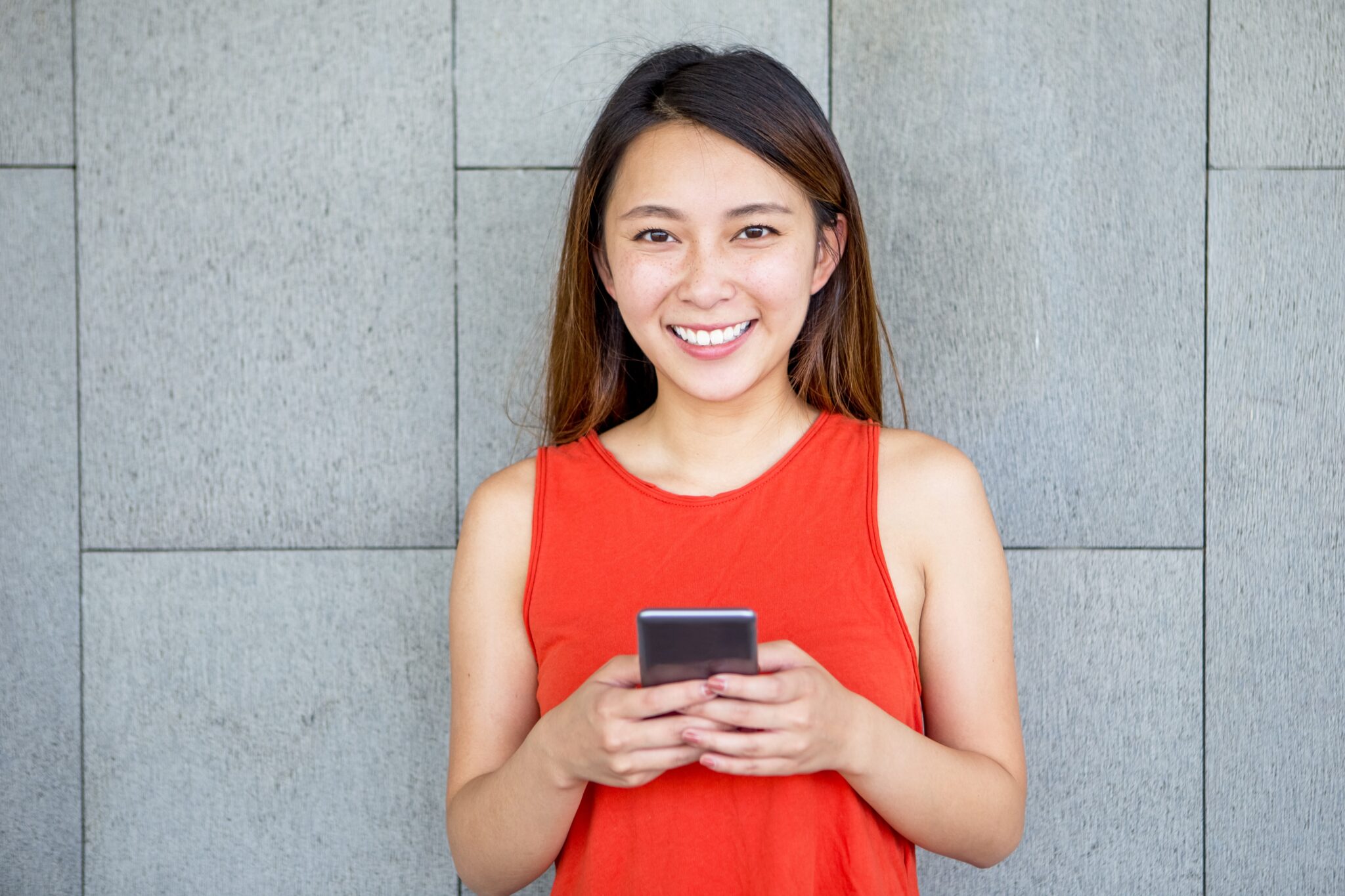 Portrait of smiling Asian girl with mobile phone